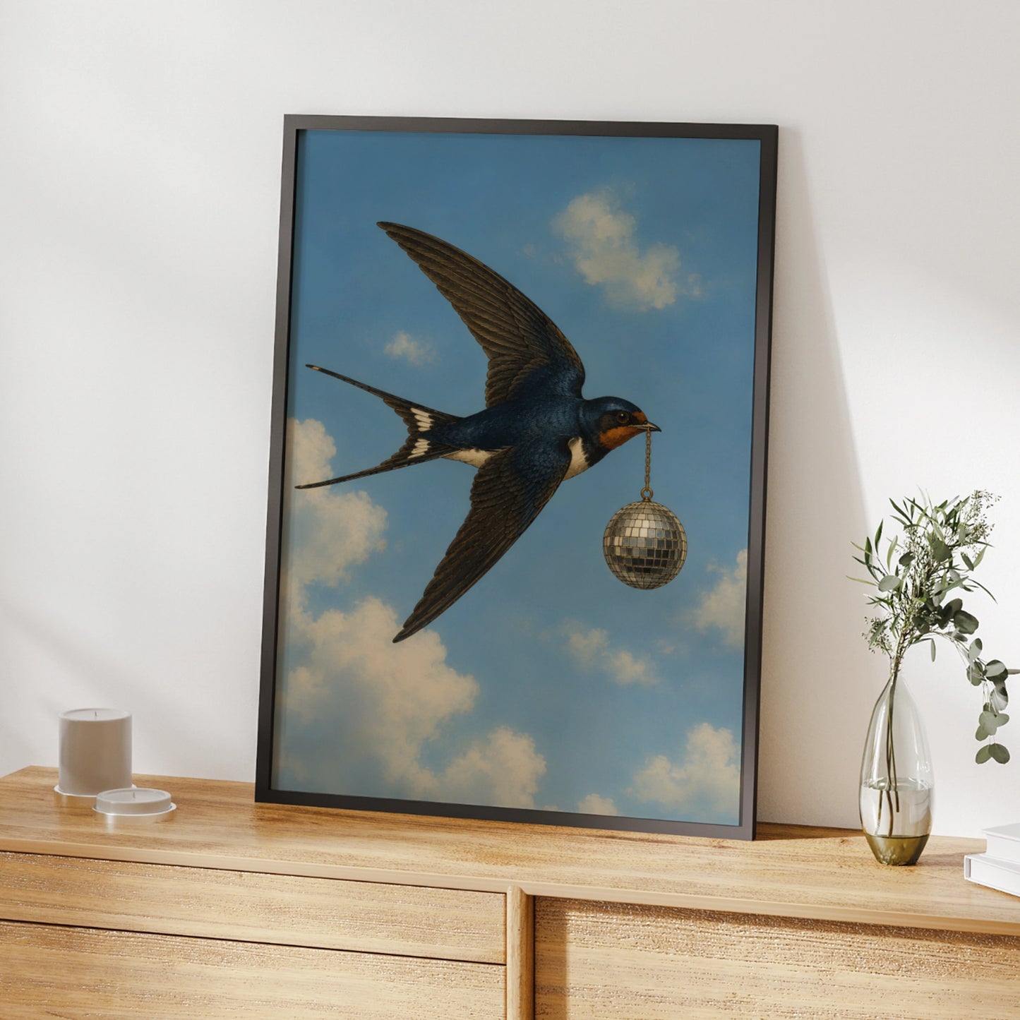 Illustrated swallow carrying a silver disco ball through a cloudy blue sky