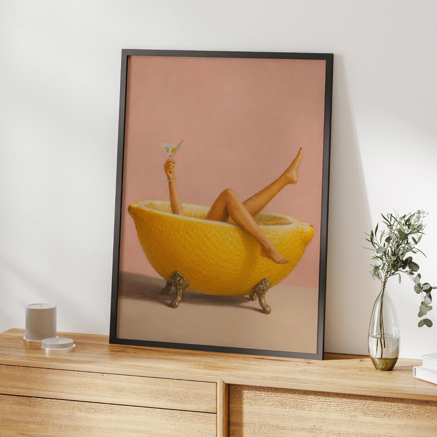 Woman relaxing in a giant lemon bath with a martini on a pink background